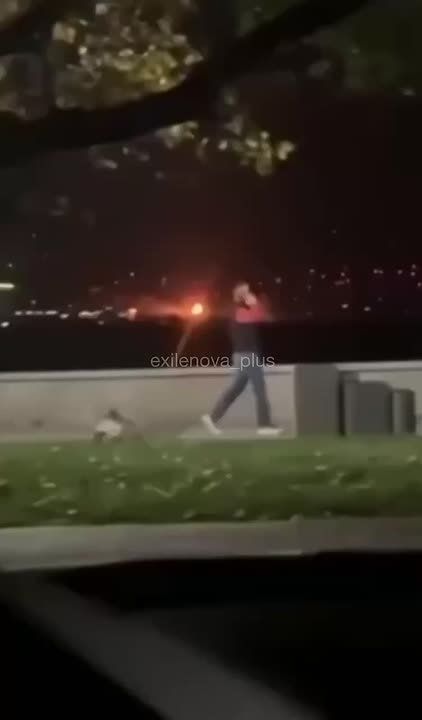 Увлеченный телефонным разговором житель Новороссийска прогуливается на фоне работы ПВО в ночном небе