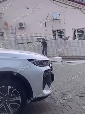 Как, зачем и куда?. В Новороссийске сняли на видео странного гражданина с не менее странной ношей – дорожным знаком на плече